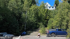 Un espace de stationnement avec un chemin de terre, des sièges extérieurs et un camion bleu.