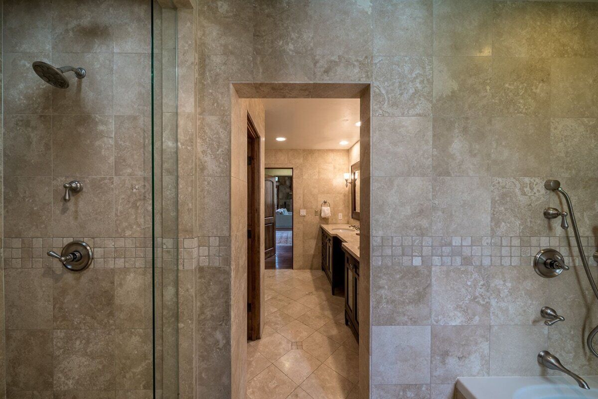 A modern bathroom with a shower, a sink, and a mirror.