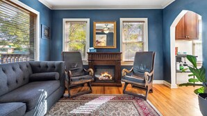 A living room with a fireplace, two armchairs, a sofa, and a patterned rug. - Peak House Hot Tub 3BR 2.5BA Close to Downtown  (Boise)