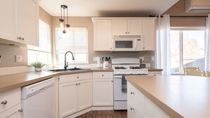 A kitchen with white cabinets, a microwave, a stove, and a dishwasher.