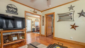 A living room with a TV, wooden entertainment unit, and a coffee table.