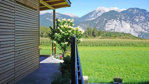 A wooden building with a balcony overlooking a green field and mountains. - Apartment Sabine by Interhome (Oberperfuss)