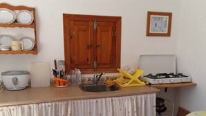 A small kitchen with a sink, a stove, and a cabinet above the counter.