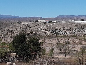 A dry, rocky landscape with sparse vegetation and a winding road. - 2-Bed Apartment - Sleeps 3 - Parking - near Albox (Albox)