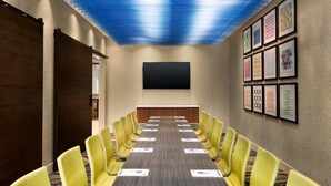 A conference room with a long table, yellow chairs, a flat-screen TV, and framed artwork on the walls. - Holiday Inn Express & Suites Canton by IHG (Canton)