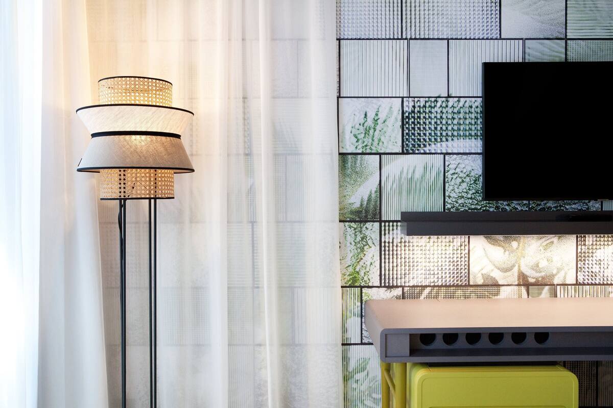 A modern living room with a flat-screen TV mounted on a wall with a geometric tile pattern.