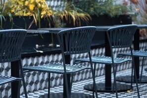 Filas de mesas y sillas al aire libre, con un suelo de patrón escocés.