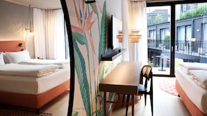 A hotel room with two beds, a dining table, and a large window with a view of the outside. - Hotel Indigo Vienna – Naschmarkt by IHG (Vienna)