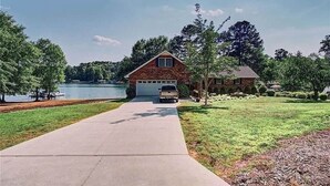 Una casa con garage, vialetto e vista sul lago.