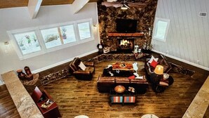 A cozy living room with a stone fireplace, wooden furniture, and a television. - Beautiful Farmhouse with serene environment. 4+ acres beautiful landscape. 
 (Wallis)