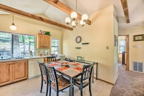 A dining area with a wooden table, chairs, and a chandelier.