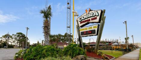 A sign for 'Cobra Adventure Park' with a digital display indicating '12 PM'.