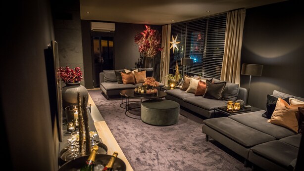 Un salon moderne avec un canapé gris, une table basse et un vase décoratif orné de fleurs.