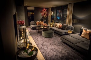 En moderne stue med en grå sofasæt, et sofabord og en dekorativ vase med blomster.