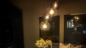 Un espace repas moderne avec une table ronde, des chaises à revêtement gris et un vase rempli de fleurs.