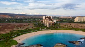 Ein Resort mit direktem Strandzugang, einem mehrstöckigen Gebäude und freiem Blick auf den Ozean.