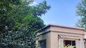 A building with a beige exterior, a large window, and a door with shutters. - Holiday Home Mendoza Leisure Time (Luján de Cuyo)
