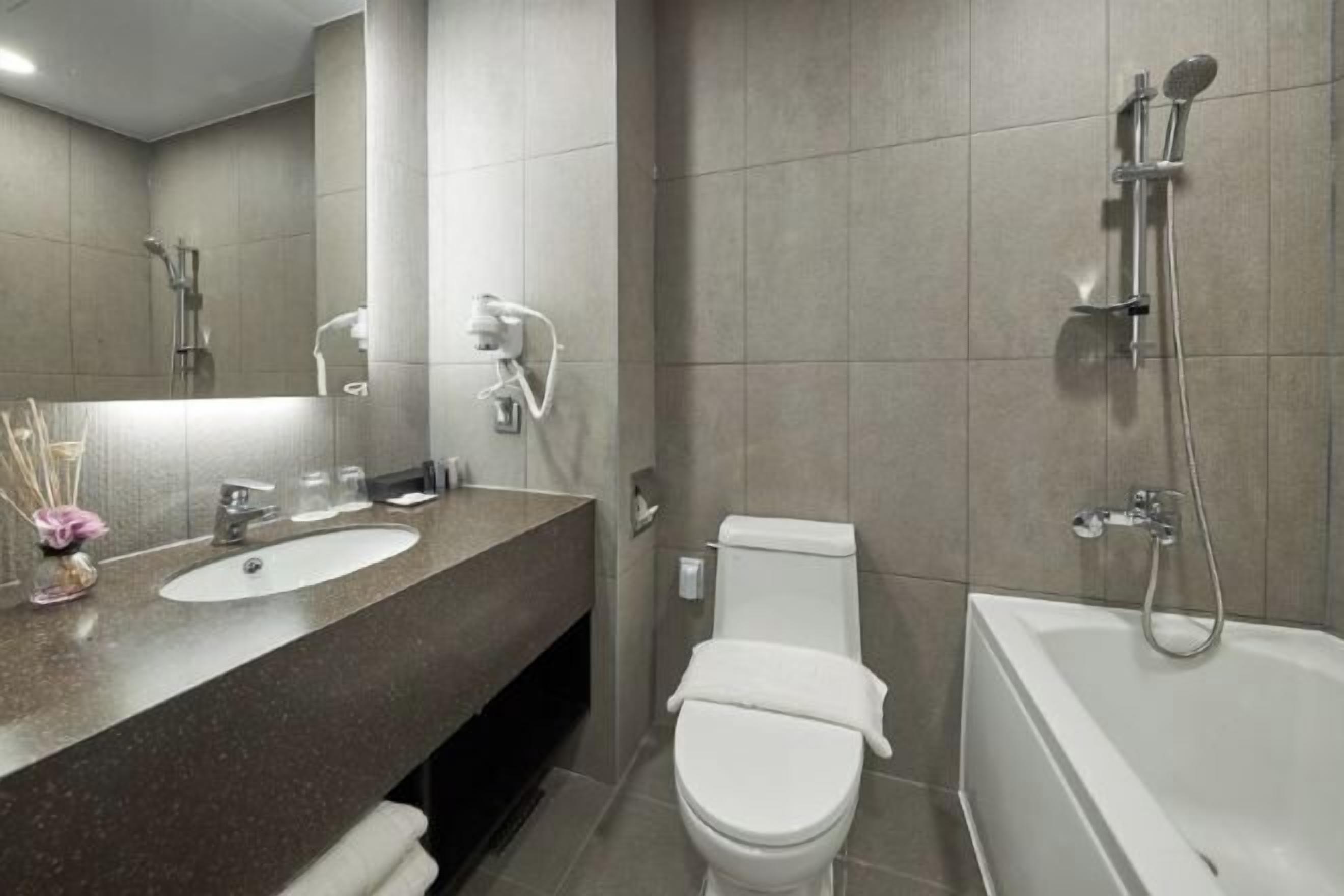 Kombinasi shower/bathtub, pengering rambut, jubah mandi, dan sandal