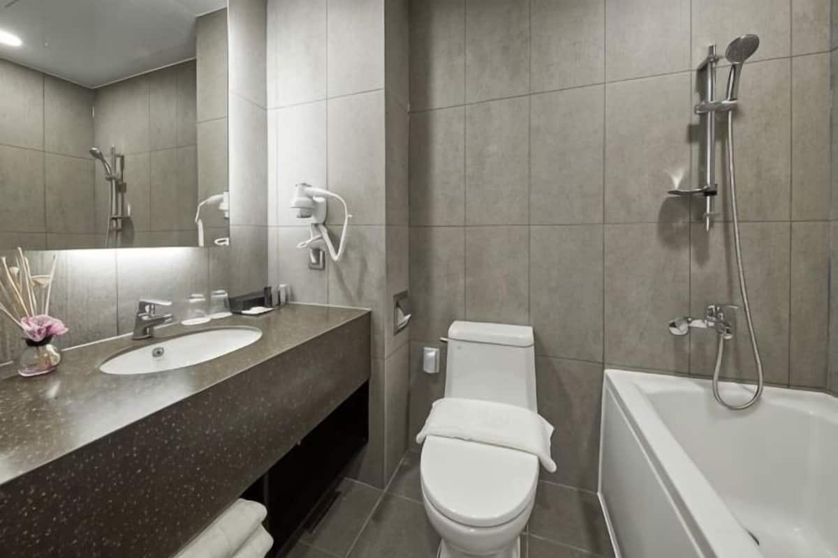 A modern bathroom with a sink, toilet, and bathtub.