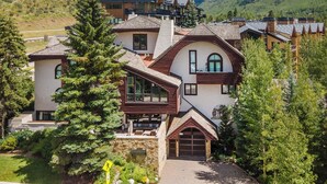 A modern house with a stone facade, large windows, and a garage. - Tyrolean 6 | Newly Updated 4BR Condo Steps to Vail Village (Vail)