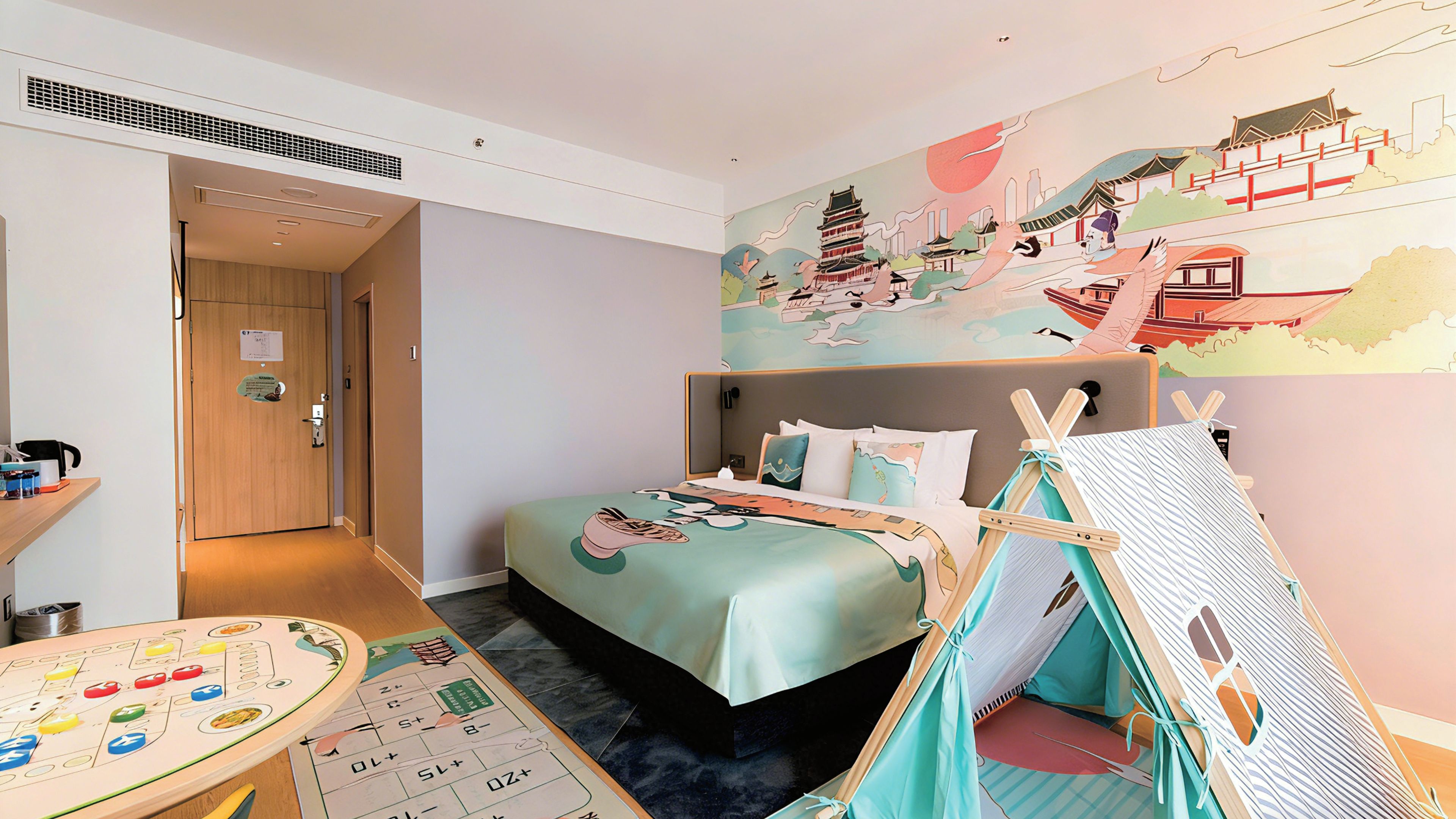 A hotel room with a bed, a small table with a board game, a tent-like structure, and a mural on the wall.