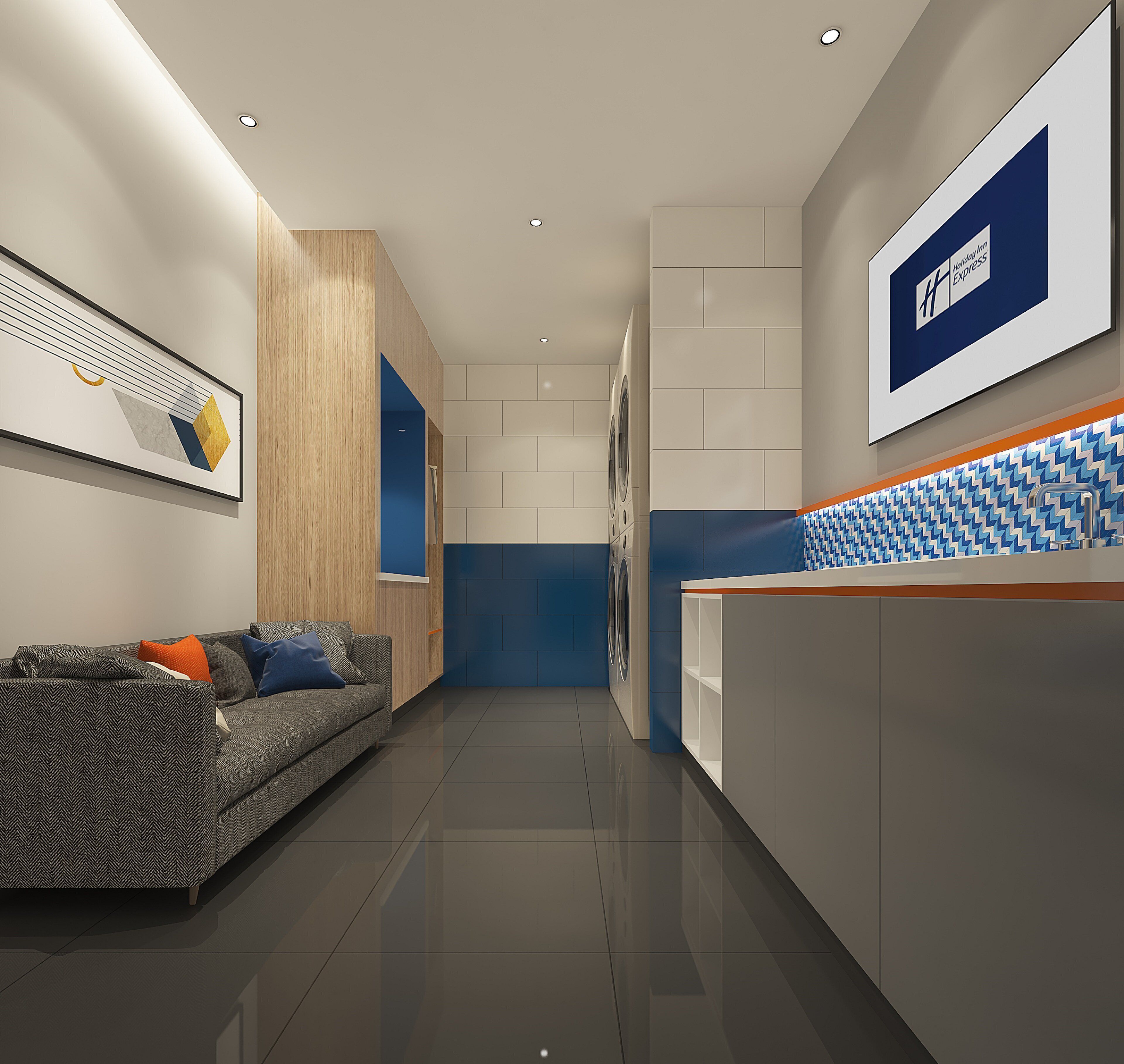A modern hotel lobby with a reception desk, a sofa with cushions, and a wall-mounted artwork.
