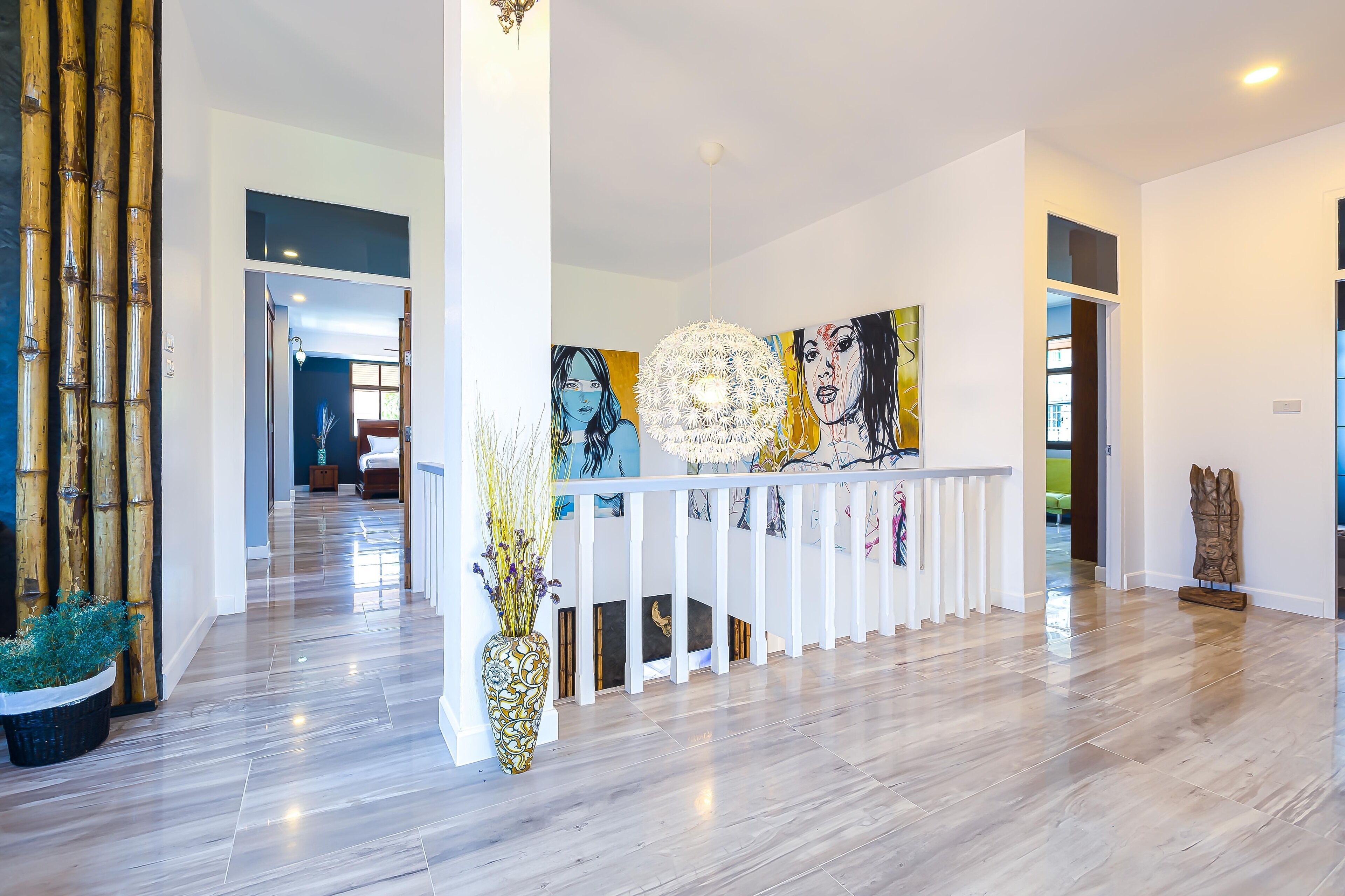 Un intérieur moderne avec un plancher en bois, une balustrade blanche et un grand tableau abstrait.