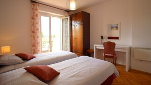 Une chambre d’hôtel avec deux lits, un bureau et une chaise.