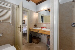 A bathroom with two sinks, a mirror, a towel rack, and a shower.