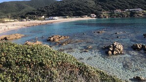 Et kystområde med klart vand, klippekyst og en strand.