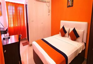 A hotel room with a bed, a desk, and a chair. - Star Inn (Tiruchirappalli)