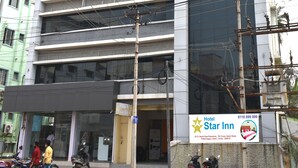 Un hotel de varios pisos con fachada moderna, unidades de aire acondicionado y un letrero que anuncia el Star Inn.