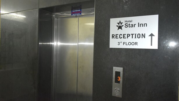 Interior de un ascensor con un cartel que indica que la recepción está en el tercer piso.