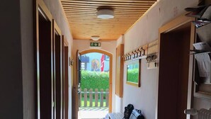 A hallway with a wooden ceiling, a bench, and a dog outside the door. - 10bedroom House Obertauern-salzburg for 30 People (Radstadt)