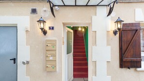 A hotel entrance with a red carpeted staircase, a door marked with the number 7, and a mailbox. - Les Studios de la faisanderie 1 (Chantilly)