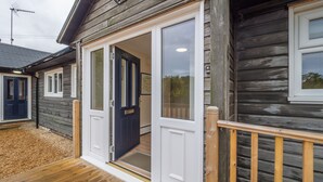 Ein Holzhaus mit Veranda, einer Schiebet ür und einer Holzterrasse.