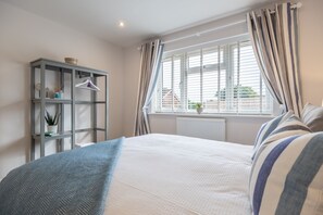 A bedroom with a bed, a wardrobe, a window with curtains, and a radiator. - The Hideaway (D), Docking, Norfolk (Docking)