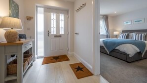 Ett modernt hotellrum med en säng, ett nattduksbord, en lampa och utsikt över omgivningarna.