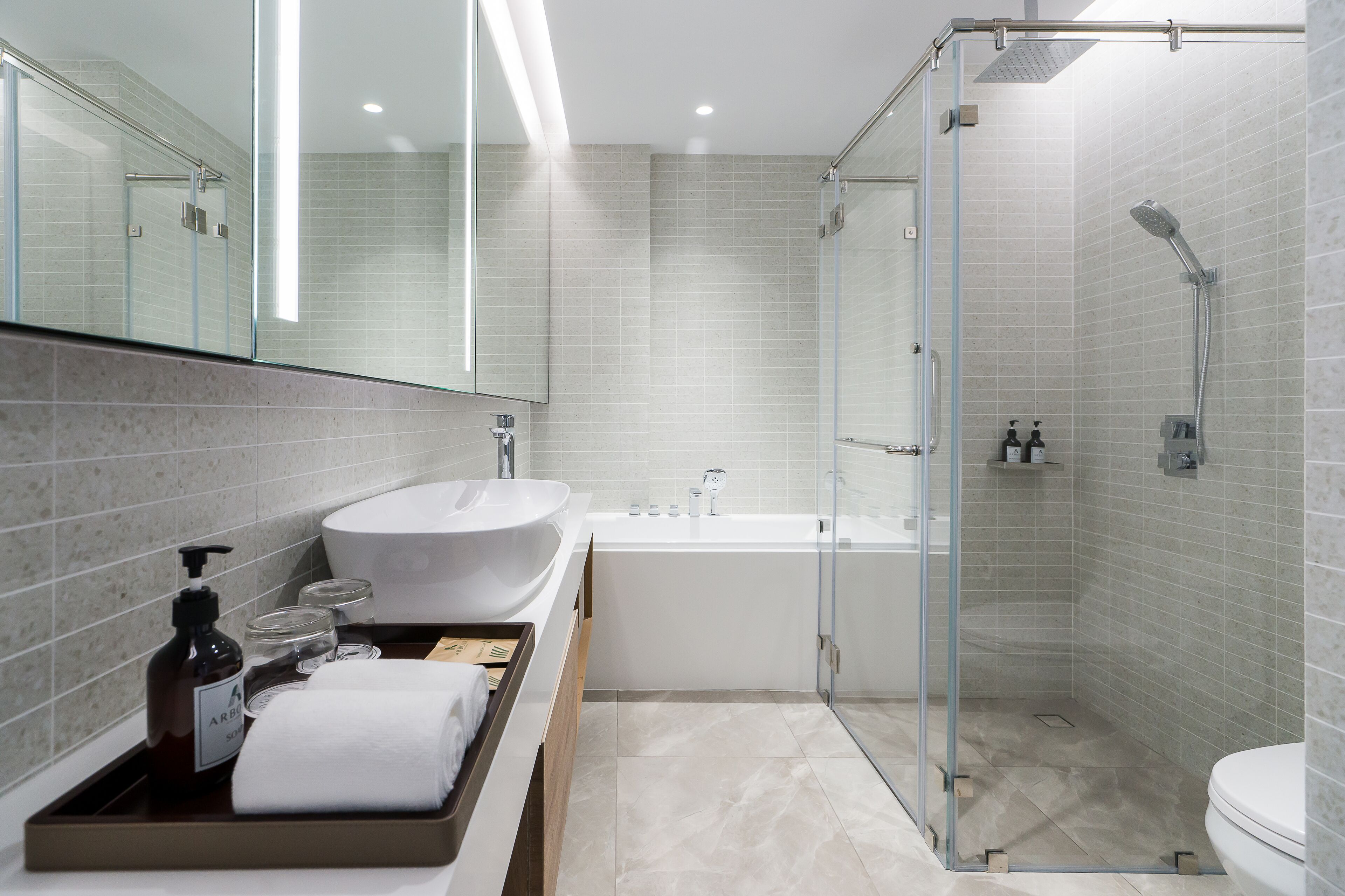 Une salle de bain moderne avec un grand lavabo blanc, une baignoire et une douche à parois de verre.
