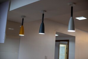 Drei Pendelleuchten hängen von der Decke in einem Raum mit einer neutralen Farbgestaltung.
