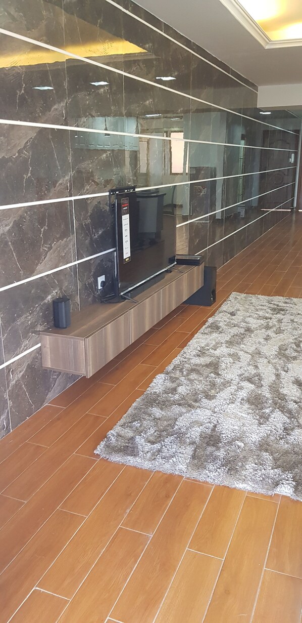 Ein modernes Interieur mit Marmorwand, einer integrierten Unterhaltungsecke und Holzboden.