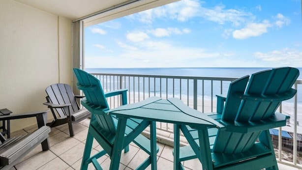 Un balcon avec vue sur l’océan, comprenant une table et des chaises.