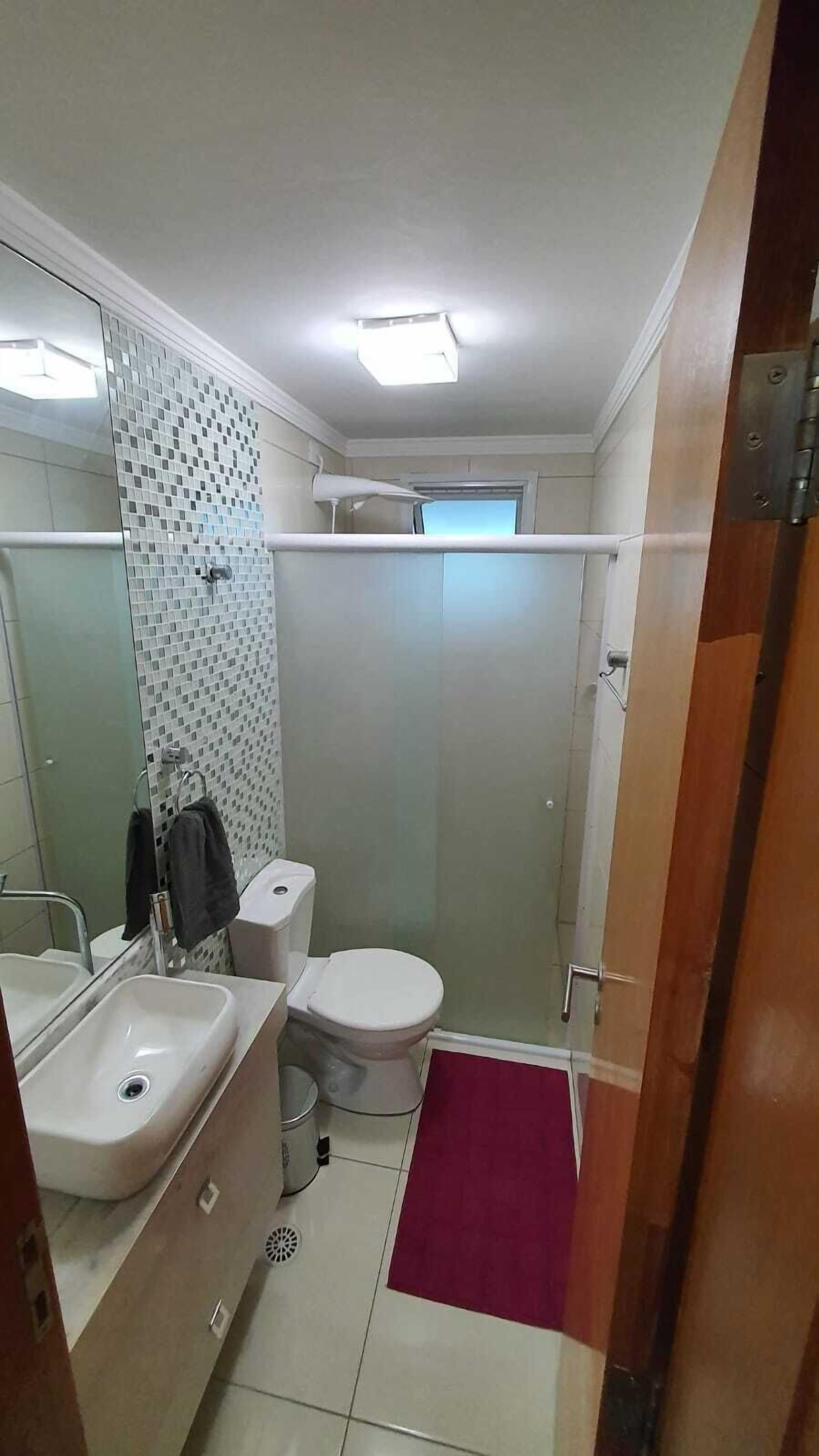 A bathroom with a sink, toilet, and shower.