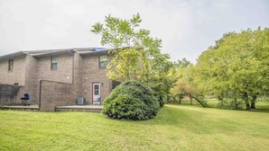 A two-story brick building with a well-maintained lawn and a large, round bush in the foreground. - A Taste of Tennessee (Knoxville, TN)