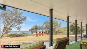 Ein überdachter Außenbereich mit Blick auf Strand und Meer.