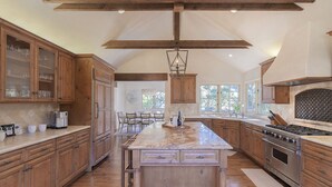 Une cuisine spacieuse avec des meubles en bois, un grand îlot central et un four encastré.