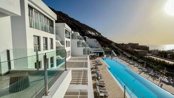 Una piscina al aire libre, sombrillas, tumbonas