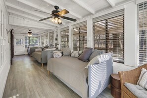 Une pièce spacieuse avec un grand lit, deux canapés et un ventilateur de plafond.