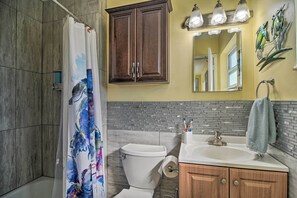 Une salle de bain équipée d’une douche, de toilettes, d’un lavabo et de meubles en bois.