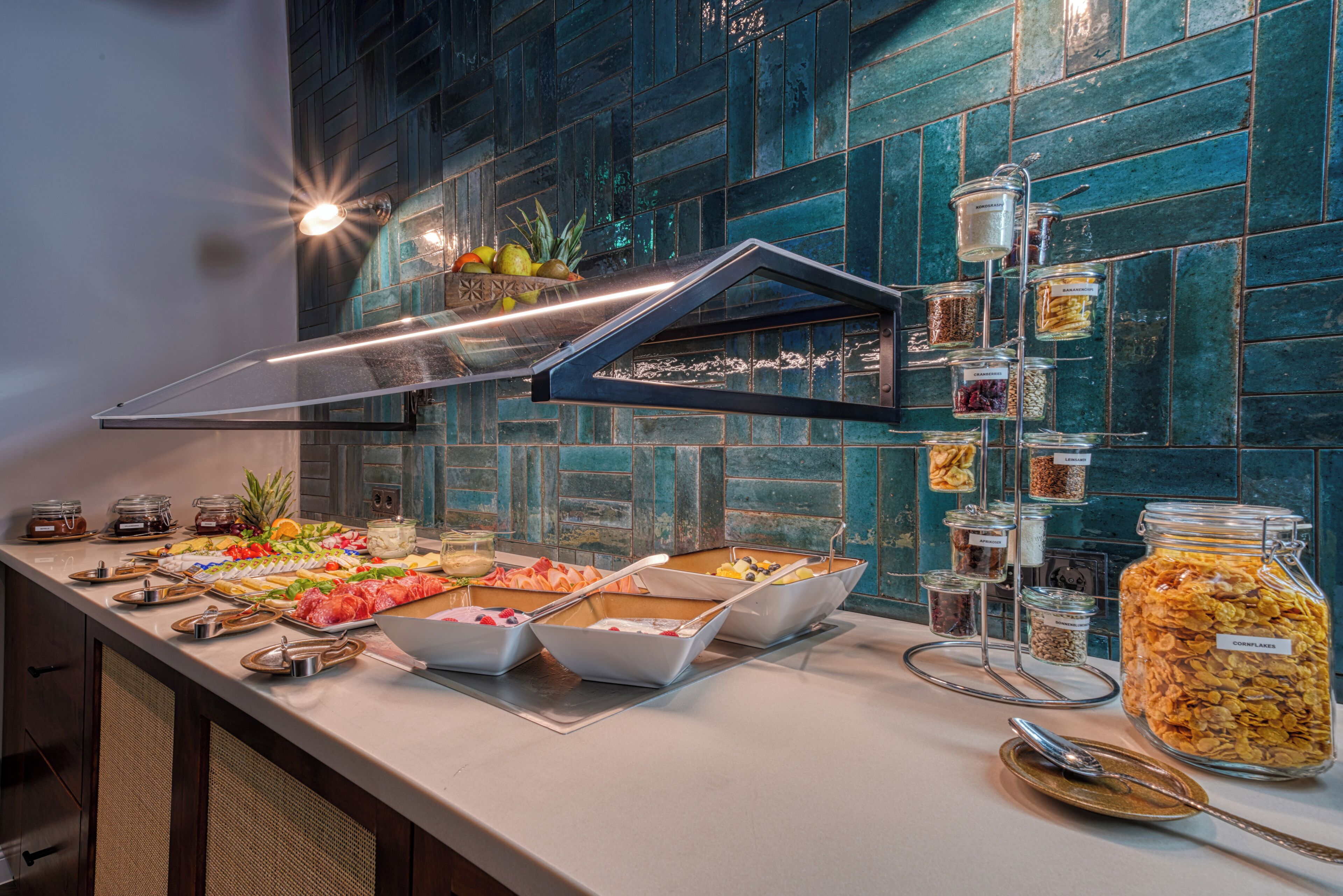 Un bufé con diversos alimentos y salsas, una vitrina de vidrio y un respuesto de azulejos.